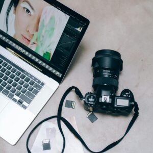 Flat lay of a DSLR camera and laptop for photo editing.